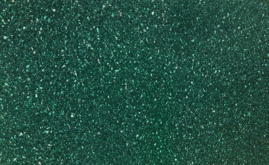 texture of grainy quartz in dark green color, close up view. green marble stone texture with splashes and white marble chips. terrazzo background for furnishing furniture.