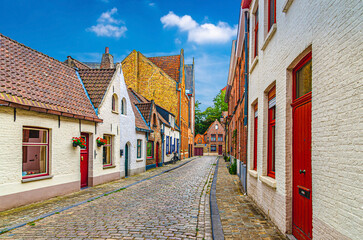 Fototapeta na wymiar Bruges old town quarter medieval district, empty narrow cobblestone street, paving stone road, colorful buildings, traditional houses in Brugge city historical centre, Flemish Region, Belgium