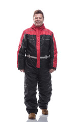 side view. a man in a winter insulated jumpsuit reading an ad on a white screen