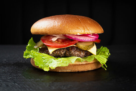 Cheeseburger with beef cutlet and cheese cheder on a black background