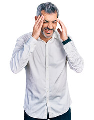Middle age hispanic with grey hair wearing casual white shirt with hand on head, headache because stress. suffering migraine.