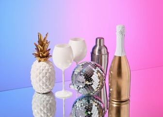 Concept of fun party and celebration. Alcohol, shaker, disco ball and pineapple.