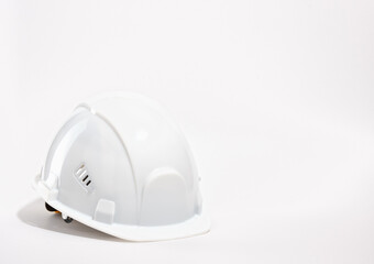 A white construction safety helmet for the head. Copy space for text.