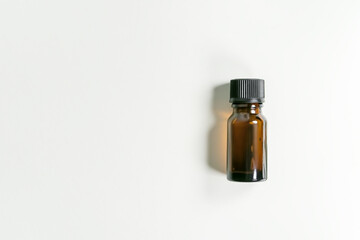 yellow glass bottle with essential aromatic oil on a white background, top view