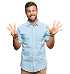 Handsome hispanic man wearing casual clothes showing and pointing up with fingers number eight while smiling confident and happy.
