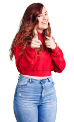 Young beautiful woman wearing casual winter sweater pointing fingers to camera with happy and funny face. good energy and vibes.