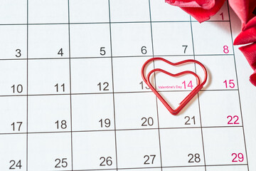 Valentines day composition with calendar page and red roses on a light background