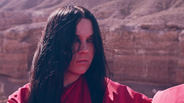 The girl in red over the canyon cliff. Slow motion.