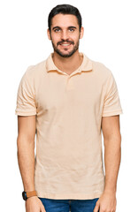 Fototapeta premium Young hispanic man wearing casual clothes looking positive and happy standing and smiling with a confident smile showing teeth