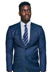 Handsome business black man wearing business suit and tie smiling looking to the side and staring away thinking.
