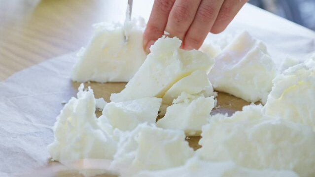 Creative process of woman Cutting Natural soy wax with knife in a table for candles preparation. Handmade.