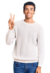 Young african amercian man wearing casual clothes smiling looking to the camera showing fingers...
