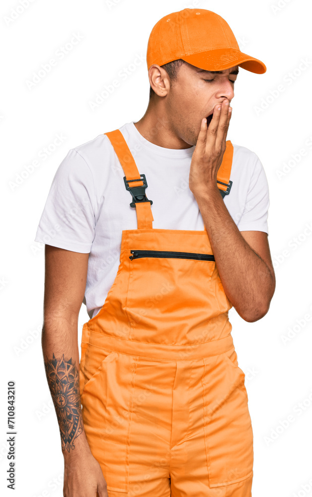 Canvas Prints young handsome african american man wearing handyman uniform bored yawning tired covering mouth with