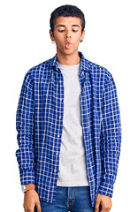 Young african amercian man wearing casual clothes making fish face with lips, crazy and comical gesture. funny expression.