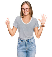 Fototapeta na wymiar Beautiful young blonde woman wearing casual clothes and glasses showing and pointing up with fingers number six while smiling confident and happy.