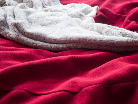 Couverture plaide tr&egrave;s douce pour l'hiver sur un canap&eacute; en tissus rouge bordeau 