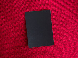 Carte noire sur fond de tissu rouge. Concept marketing de carte VIP