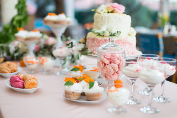 Dessert table for a party. Cake, cupcakes, sweetness and flowers