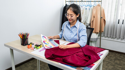Asian woman fashion designer holding color sample and choosing c
