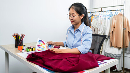 Asian woman fashion designer holding color sample and choosing c