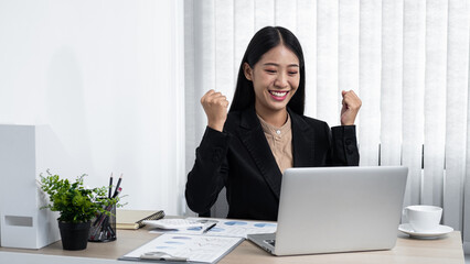 Young secretary woman smiling and looking on laptop with raising