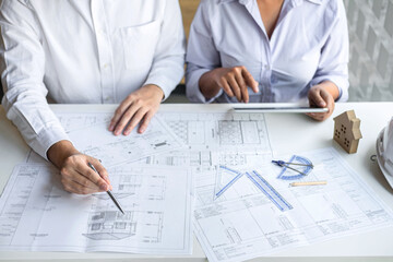 Team of construction engineering or architect partner discuss a blueprint while checking information on drawing and sketching meeting for architectural project with engineering equipment tool