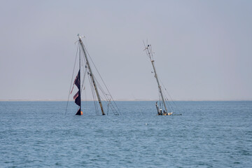 masts of wreck emerging from water out of harbor, Walvis Bay, Namibia