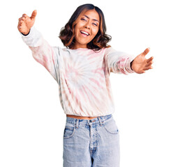 Young beautiful mixed race woman wearing casual tie dye sweatshirt looking at the camera smiling with open arms for hug. cheerful expression embracing happiness.
