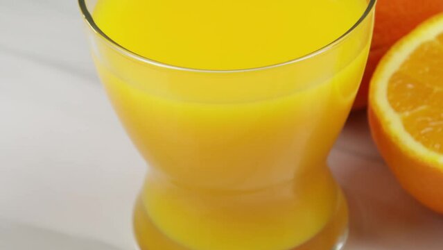 verre de jus d'orange et oranges fraiches sur une table