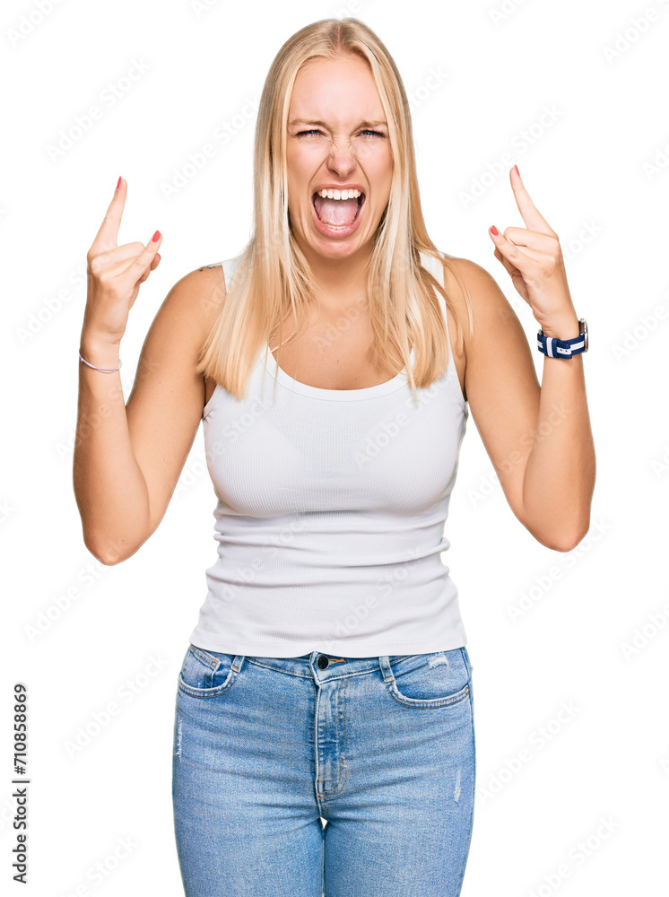 Poster young blonde girl wearing casual style with sleeveless shirt shouting with crazy expression doing ro