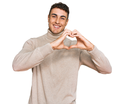 Hispanic young man wearing casual turtleneck sweater smiling in love showing heart symbol and shape with hands. romantic concept.