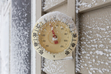 Snow Capped Thermometer Mounted on Wooden Siding of House Showing Freezing Temperatures