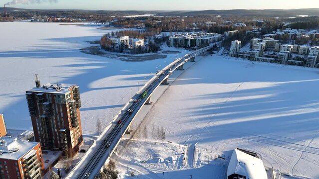 Jyv&auml;skyl&auml; "Kuokkalan silta" (Kuokkala bridge). Snowy winter in Jyv&auml;skyl&auml;, Finland. Traffic and cars driving on bridge on snowy icy lake.