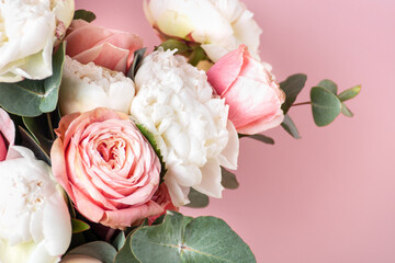 Roses, peonies, eucalyptus, flower arrangement on a pink background, close-up. Postcard for...
