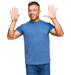 Handsome muscle man wearing casual clothes showing and pointing up with fingers number ten while...
