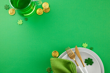 Festive St. Patrick's Day tablescape. Top view shot of plates, cutlery, napkin, green beer, coins,...