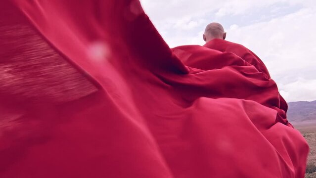A monk in red prays in the steppe. A divine ritual.