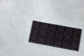black almond chocolate bar isolated on grunge gray background from top view