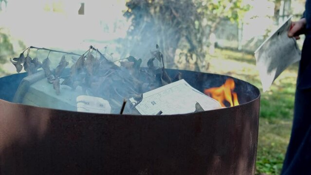 Garden and house garbage burning in a bin incinerator close up
