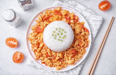 Tomato and eggs stir fry with rice in a plate