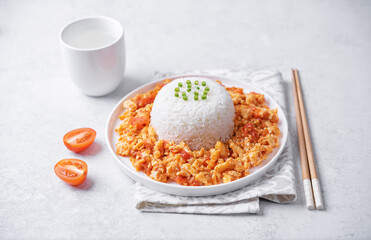 Tomato and eggs stir fry with rice in a plate