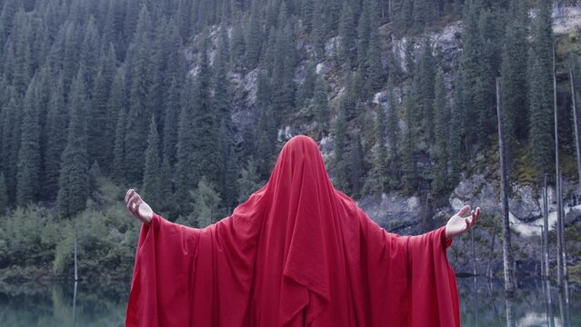 A monk in red prays in the steppe. A divine ritual.