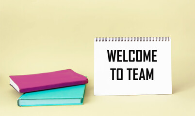 WELCOME TO THE TEAM text concept written on a notepad with diaries on a light background