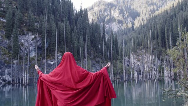 A monk in red prays in the steppe. A divine ritual.