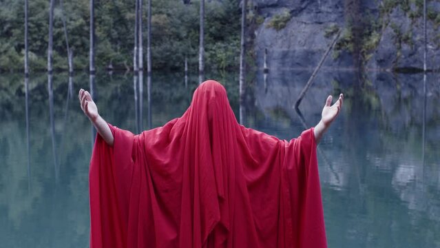 A monk in red prays in the steppe. A divine ritual.