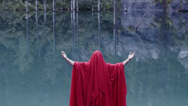 A monk in red prays in the steppe. A divine ritual.