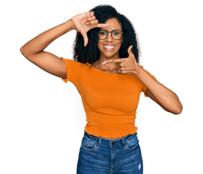 Middle age african american woman wearing casual clothes and glasses smiling making frame with hands and fingers with happy face. creativity and photography concept.