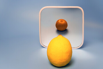 A lemon in front of a mirror reflecting as a tangerine, symbolizing transformation or perception....