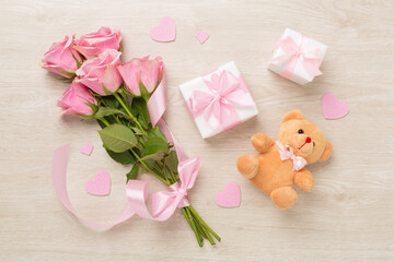 Pink roses with hearts and gifts on wooden background, top view. Valentines day concept