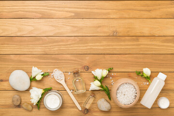 Flat lay with spa products and flowers on wooden background